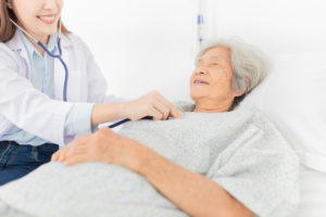 close up hand of doctor, asian female doctor use stethoscope listening and screening old asian patient, elderly health check up , palliative care